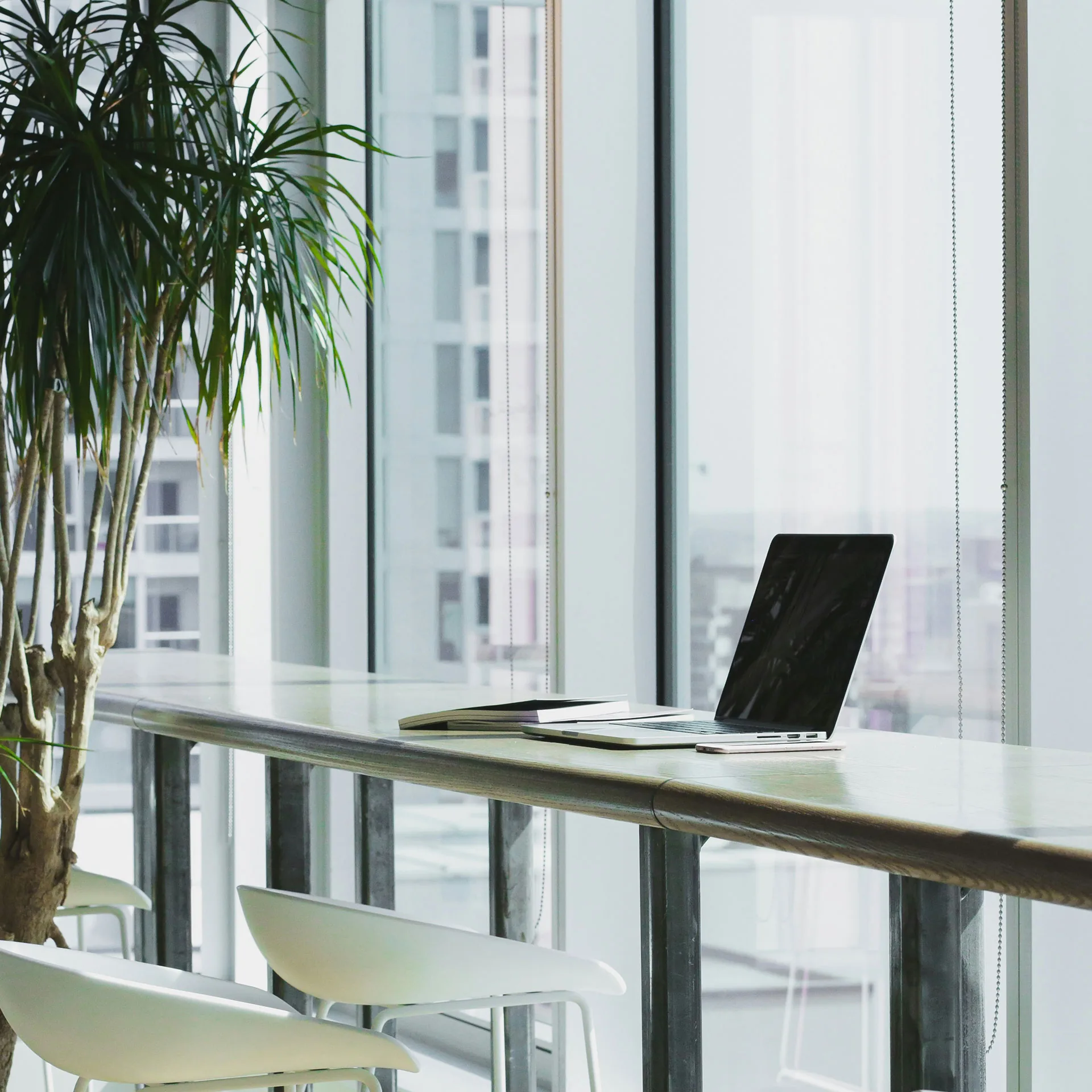 Laptop i kontorslandskap med stora fönster